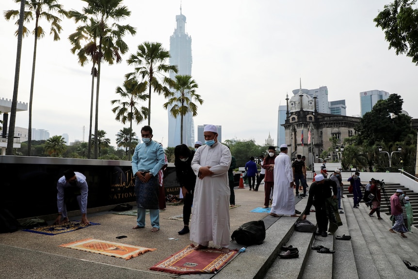 Muslims offer prayer outside the National Mosque in Kuala Lumpur during the COVID-19 outbreak.