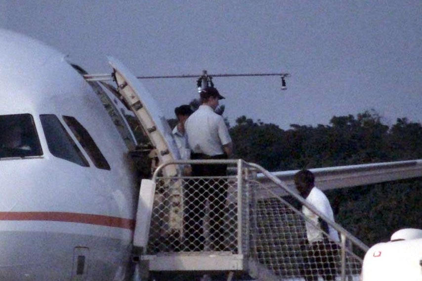 Sri Lankan asylum seekers board a plane on Christmas Island.