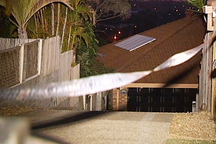 A garage door with police tape across the driveway.