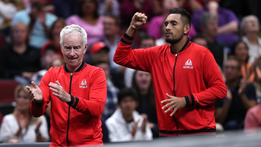 John McEnroe claps as Nick Kyrgios clenches a fist in celebration with both dressed in red for Team World at the Laver Cup.