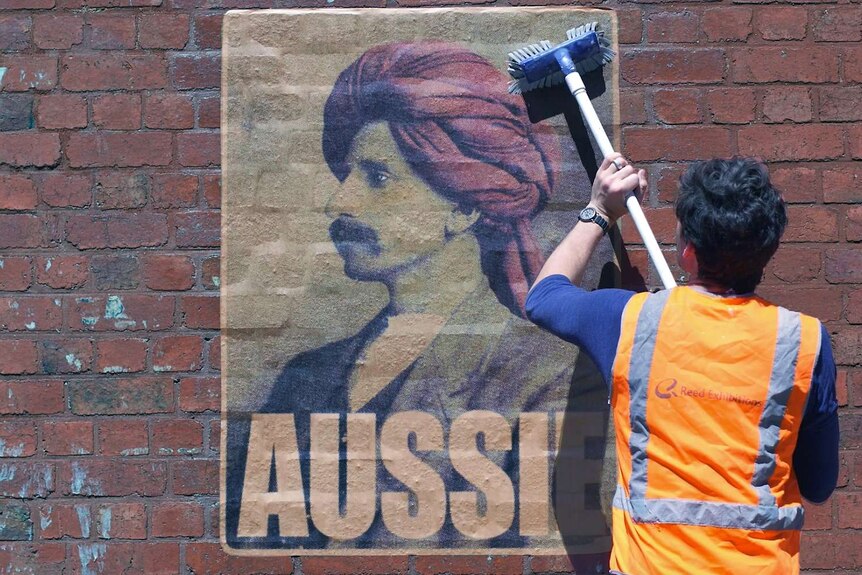 Peter Drew sticking up an Aussie poster