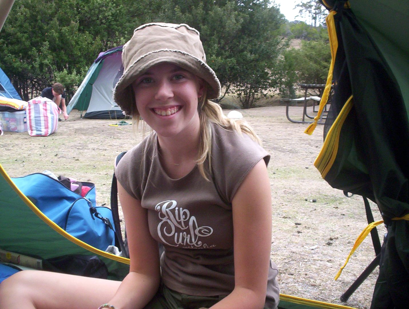 A 14 year old girl sits on the ground. 