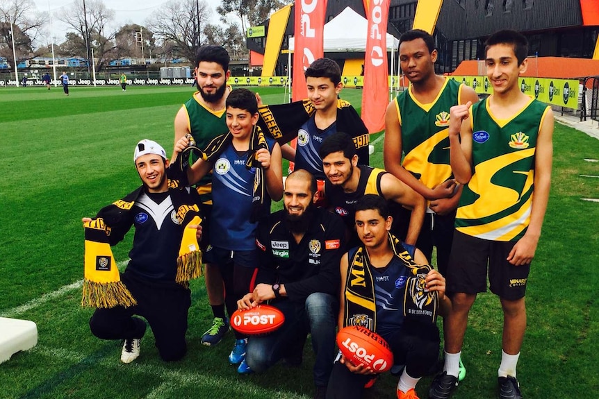 Richmond defender Bachar Houli (centre) poses with kids at a footy clinic
