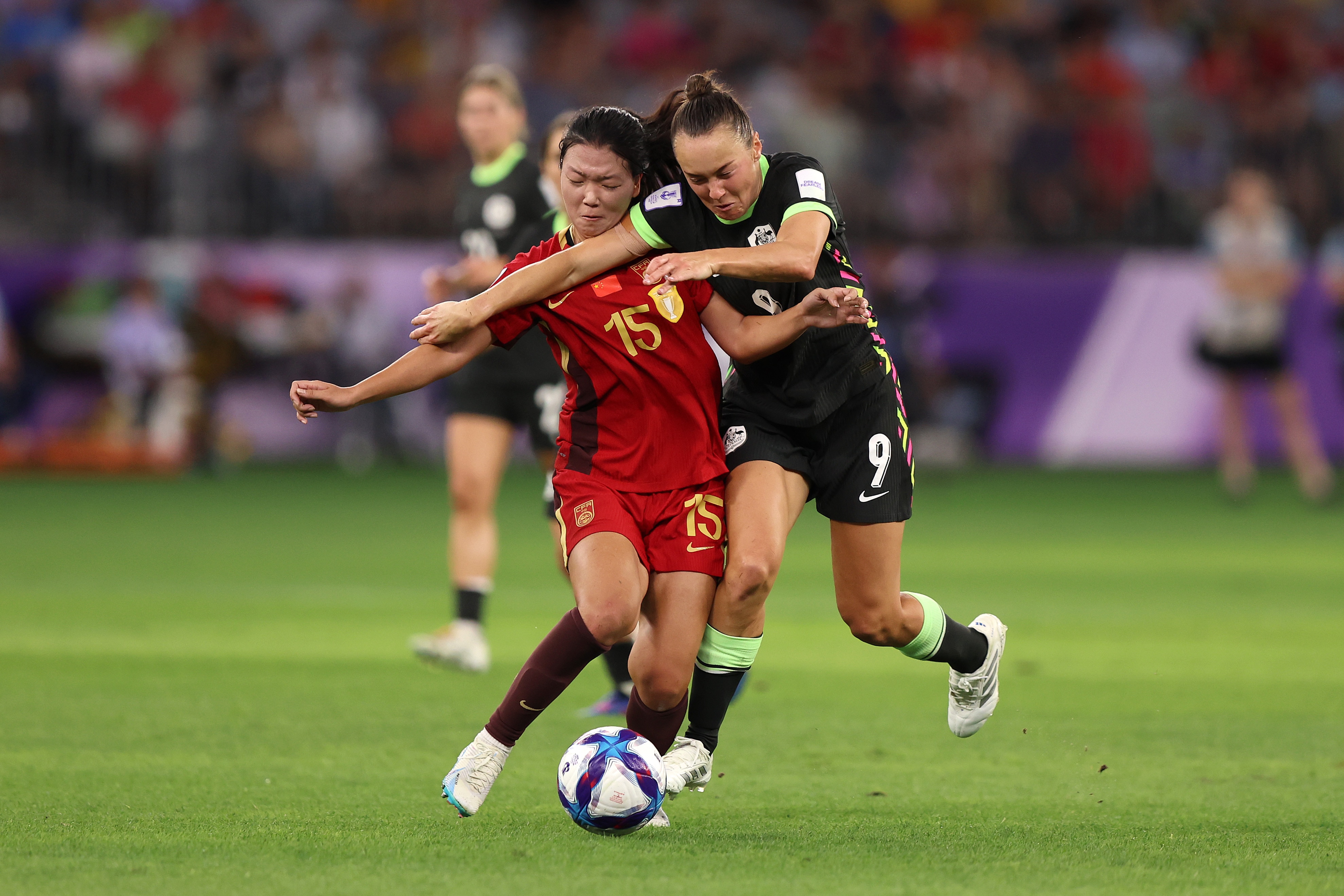 China player Wang Aifang is shoulder to shoulder with Australia's Caitlin Foord as they battle to win the ball