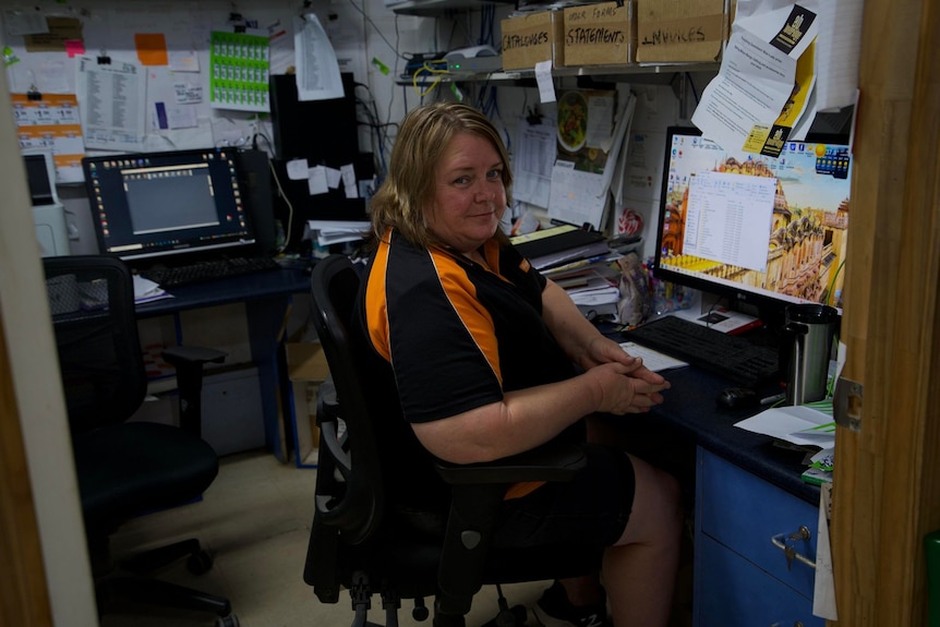 Woman sitting at desk in black shirt