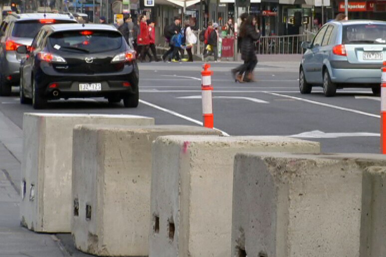Concrete bollards at Federation Square, with Flinders Street in the background.