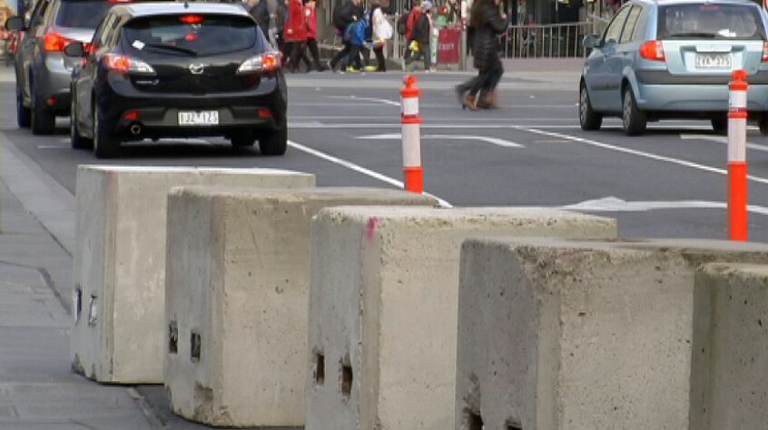 Concrete bollards at Federation Square, with Flinders Street in the background.