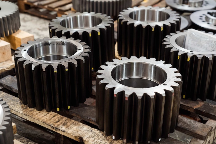 A close-up shot of large gear cogs on pallets.