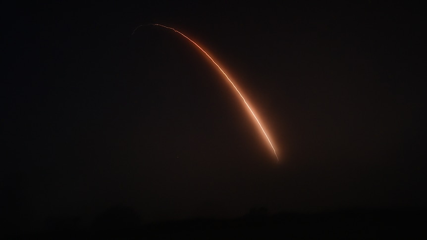 A red missile stream against the balck night sky.