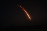 A red missile stream against the balck night sky.