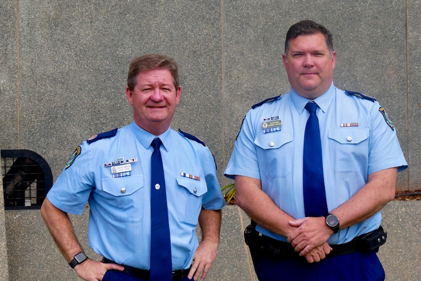 Two police officers in uniform standing side by side.