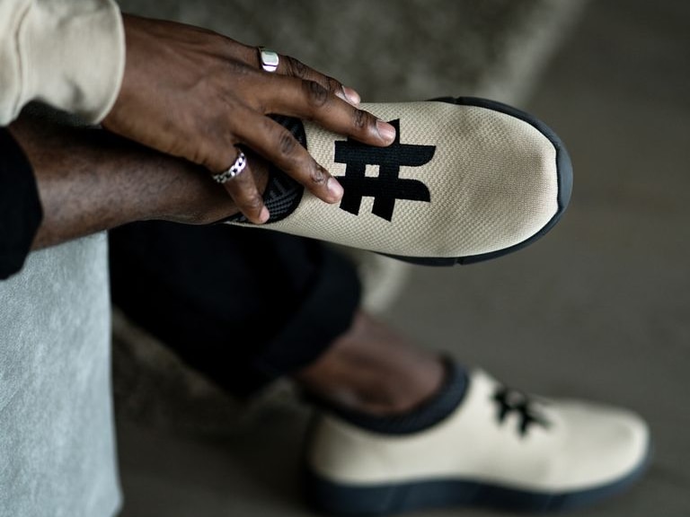 a pair of men's sneakers being modelled