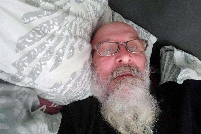 A man rests his head on a pillow.