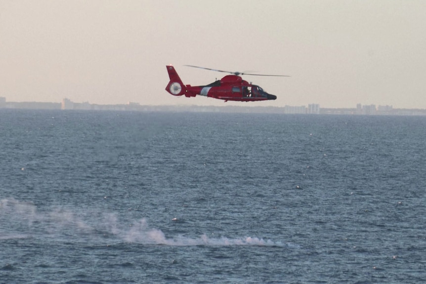A red helicopter over the ocean