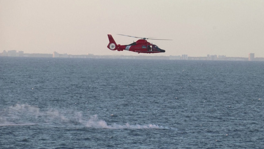 A red helicopter over the ocean