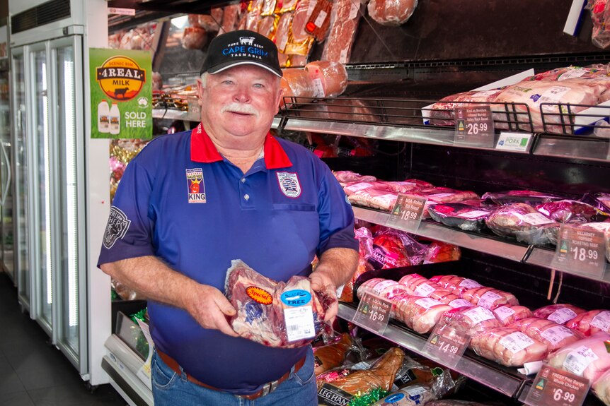 Toowoomba butcher John Yeo holding a slab of meat in his shop.
