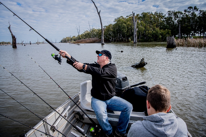 A man and a child fishing off a boat.