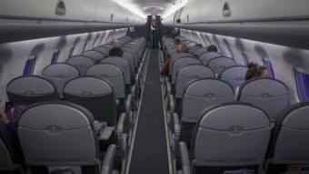 Only a few passengers are seated in a near-empty airliner cabin.