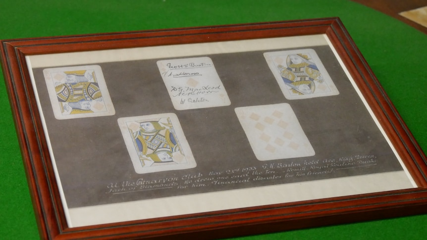 A 10, jack, queen, king and an ace of diamonds mounted in a picture frame. The ace has several signatures written on it.