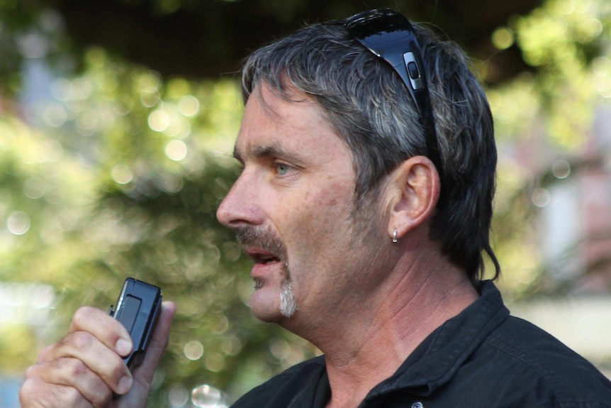 Mick Buchan, CFMEU WA state secretary, holds loudspeaker and mic