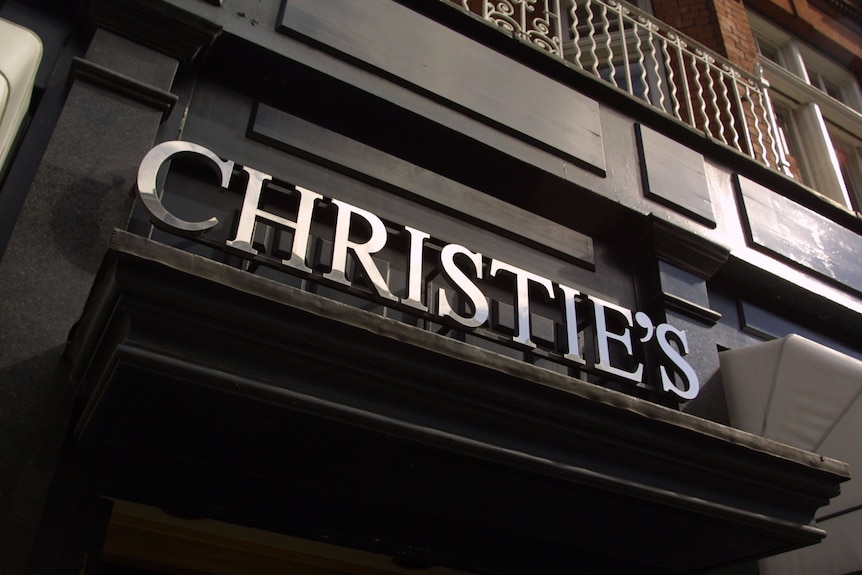 A close up of the word Christie's in silver capital letters affixed on the side of a black building.