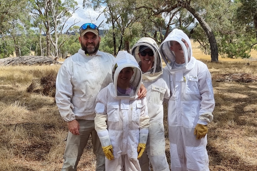 Daniel Hooper with family in beekeeping suits