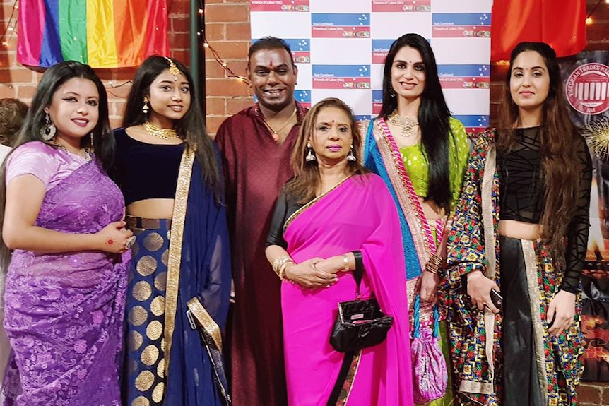 A group of people wearing traditional Indian outfits.