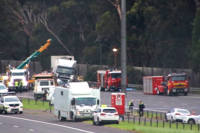 A number of police and emergency vehicles on the Eastern Freeway at a crash scene.