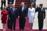Donald and Melania Trump stand beside Benjamin and Sara Netanyahu. A red carpet, plane steps and saluting men are visible.