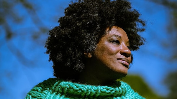 Black woman wearing a bright green turtle neck knitted jumper