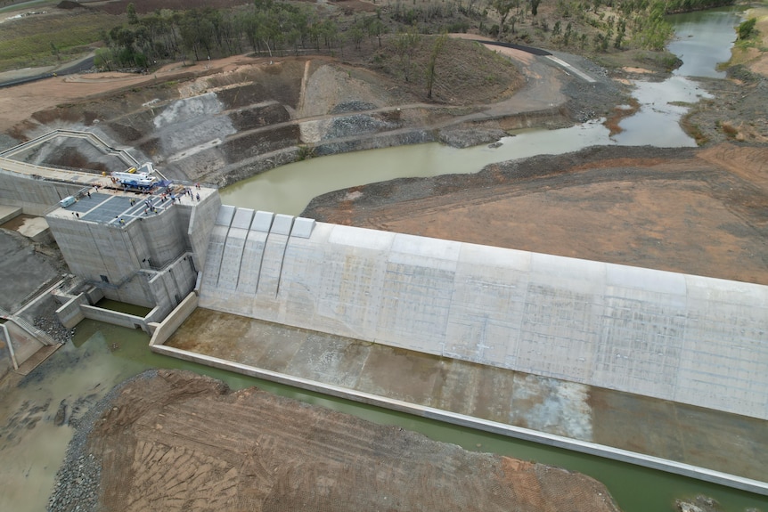 A large cement structure for a weir with a river and other infrastructure
