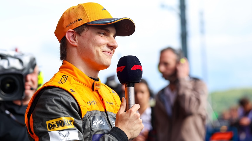 Oscar Piastri speaks into a microphone at the F1 Grand Prix in Belgium.