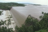 A huge body of water spills over a dam wall.