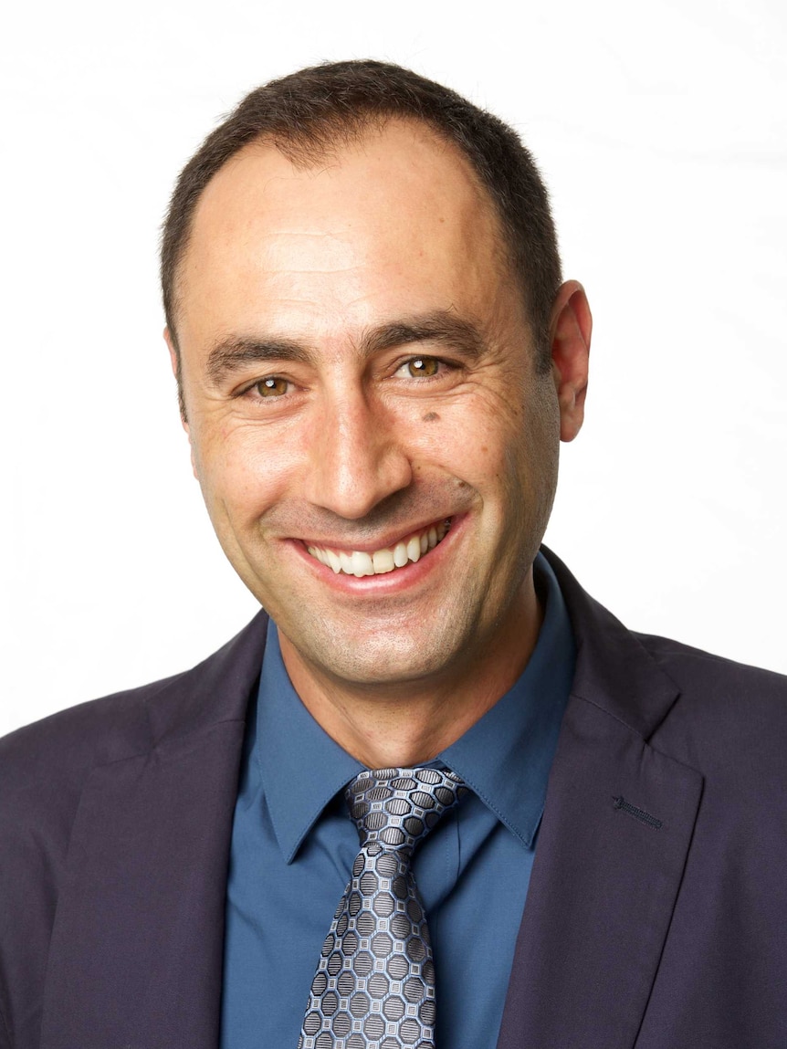 A professional headshot of Elias Aboutanios