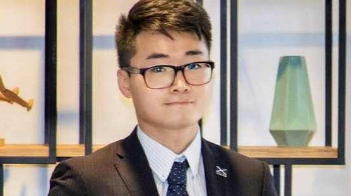 Simon Cheng dressed in a suit.