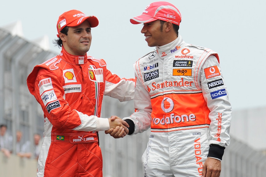 A 2008 photo shows Felipe Massa and Lewis Hamilton, wearing their racing suits, shake hands at a photoshoot