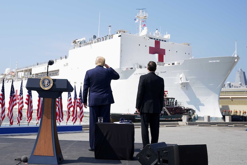 Donald Trump salutes a giant naval ship