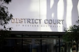 A close-up shot of the District Court of WA in Perth, showing signage on the building's front facade with the court's name.