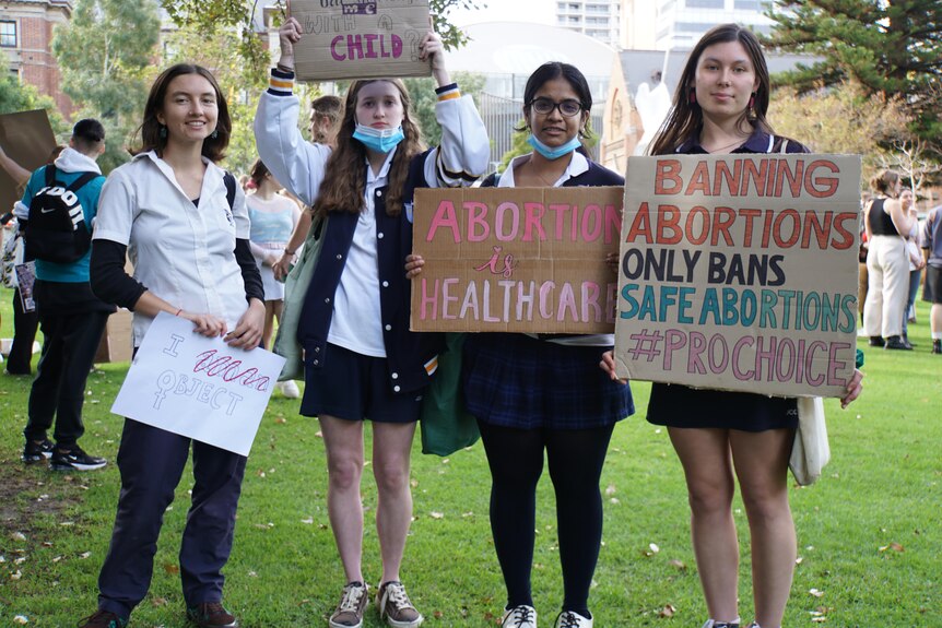 Four female high school students hold placards in support of abortion rights