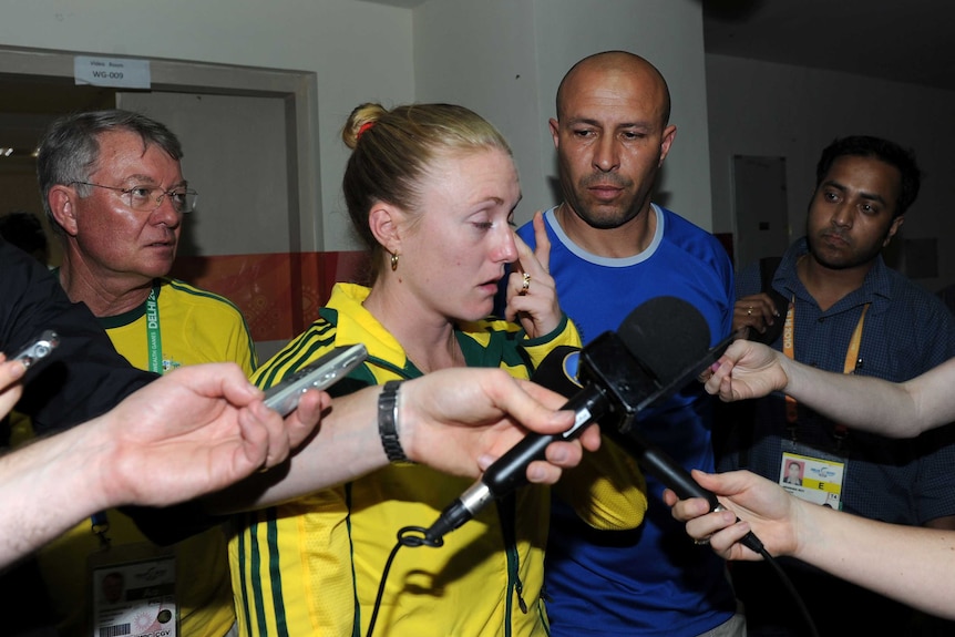 Sally Pearson wipes away a tear at a media conference after being disqualified following the 100 metres final in Delhi.