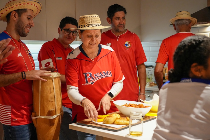 Panama soccer fans prepare a traditional meal in a kitchen.