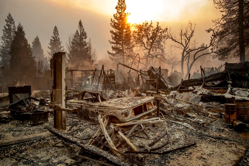 A vintage car rests among debris as the wildfire tears through Paradise.