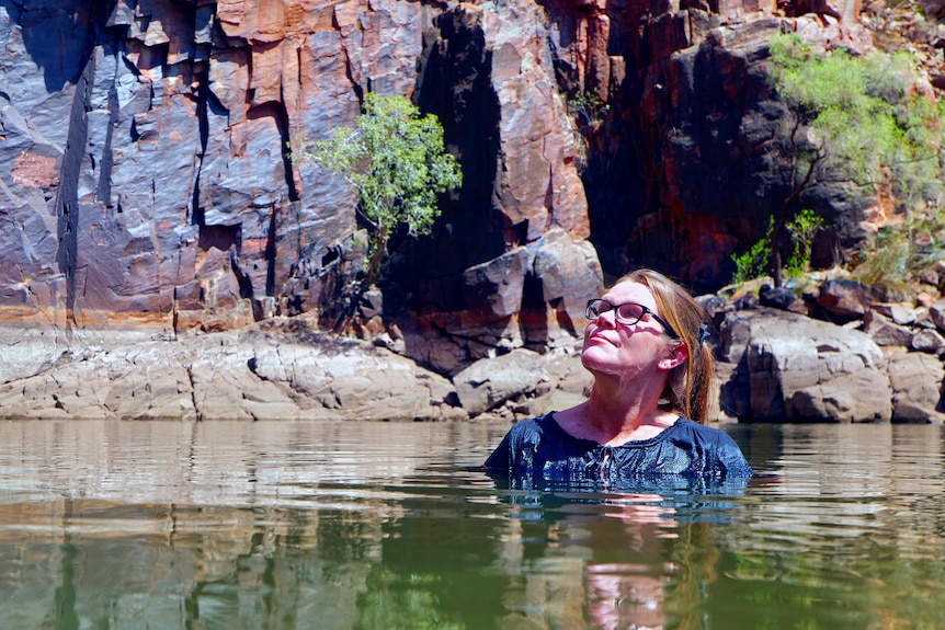 Kylie swimming in a water hole looking up at the skies