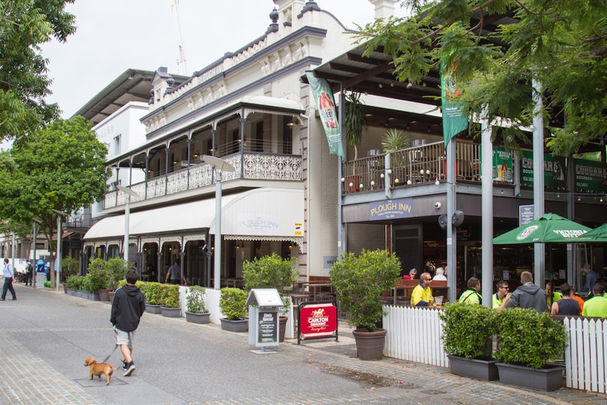 A hotel with a beer garden to the right on a cobbled street in Brisbane.