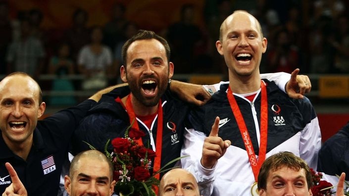 United States volleyball players and coach Hugh McCutcheon, bottom centre, celebrate victory