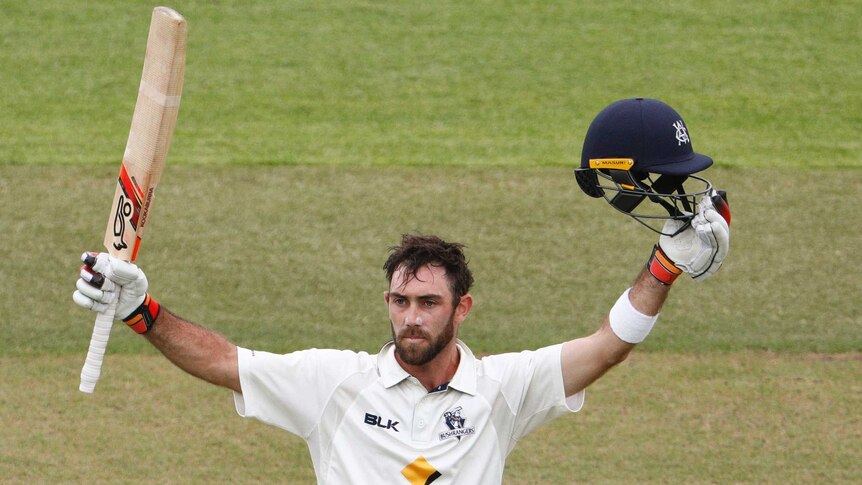 Glenn Maxwell raises his bat to acknowledge the crowd after reaching a double century for Victoria in the Sheffield Shield.