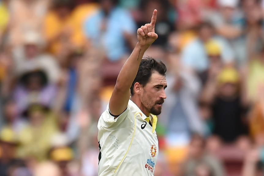 Australia bowler Mitchell Starc runs and points a finger in the air to celebrate a South African wicket.
