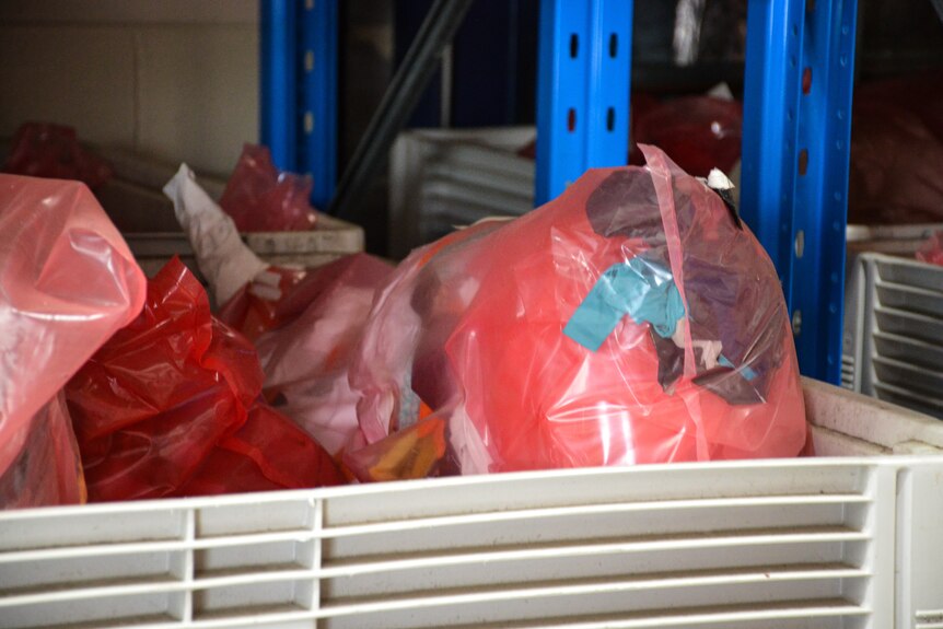 The red plastic bags are in tubs, and you can see gloves and other items through the plastic