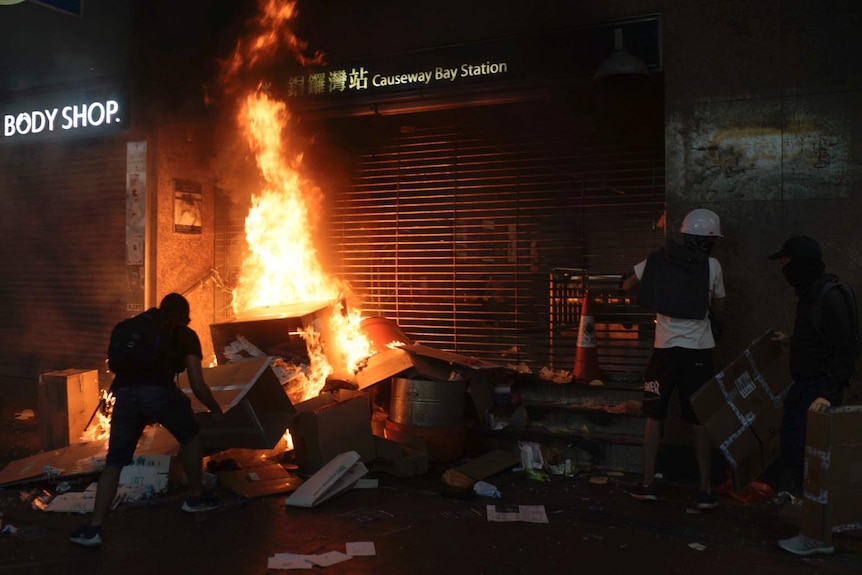 Protesters set cardboard boxes on fire at the entrance to the Causeway Bay station in Hong Kong.