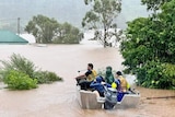 people in a boat on flooded waters